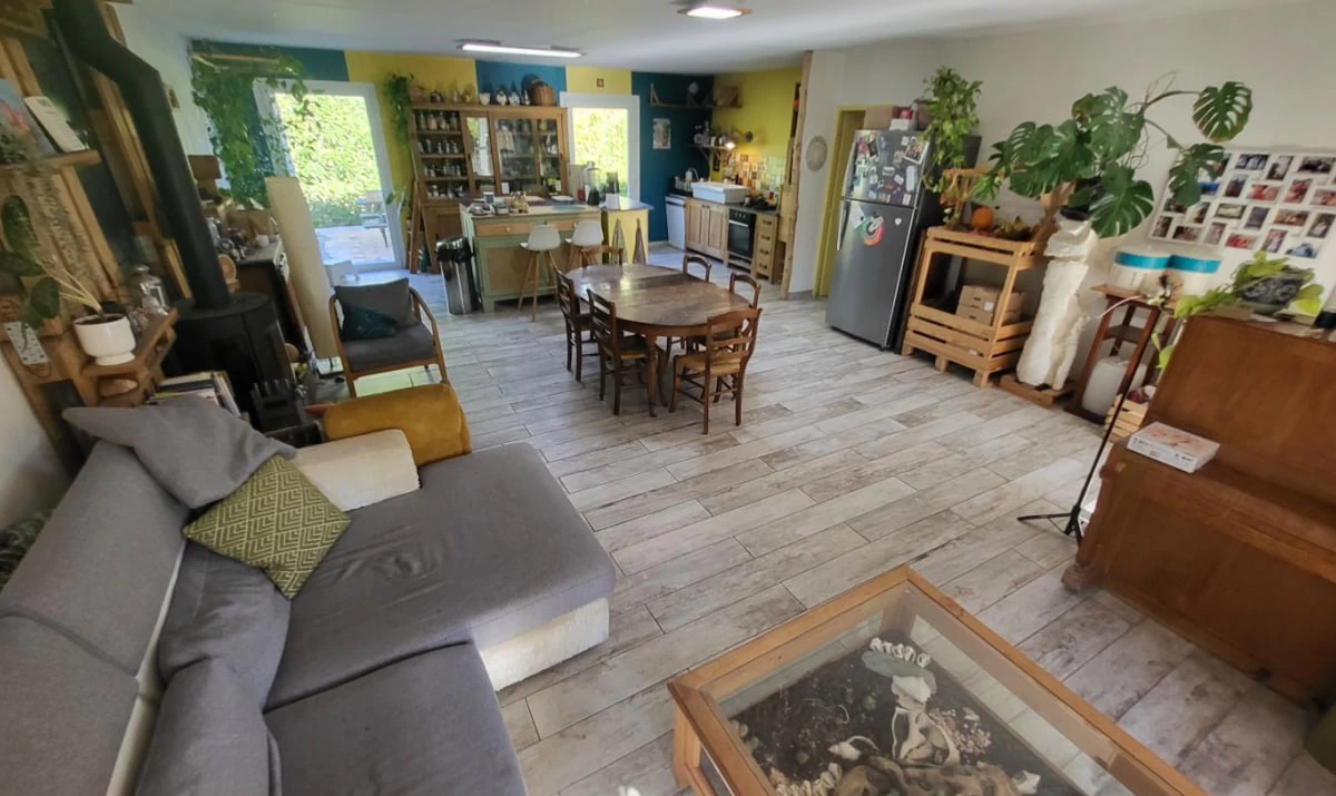 Salon i kuchnia domu w Langlade z centralną wyspą i piecem na drewno