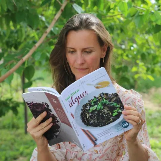 Leserin blättert im Buch Cuisiner les algues
